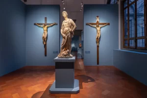 La prima sala della mostra Donatello. Il Rinascimento, a Palazzo Strozzi, con il David di marmo di Donatello e i crocefissi di Donatello e Brunelleschi (Ela Bialkowska/OKNOstudio)